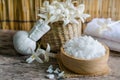 White spa salt in wooden bowl over blur herbal massage compress and fragrance flower and soft white towel