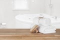 White spa towels on wooden table over defocused bathroom background