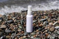 White spay bottle standing at the ocean coast