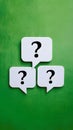 White speech bubbles with question marks on green background Royalty Free Stock Photo