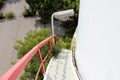 White spiral metal stairs mounted on side of large abandoned storage silo with red security fence and large light leading to Royalty Free Stock Photo