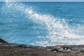 White splashes of a wave crashing against a breakwater