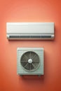 White Split System Air Conditioner Mounted on a Solid Orange Wall with White Components HVAC Royalty Free Stock Photo