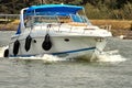 White sports boat with blue roof during the fast ride over the water of a canal Royalty Free Stock Photo