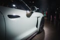 White sports car showcasing sleek design at exhibit with dramatic lighting and blurred figures. Royalty Free Stock Photo