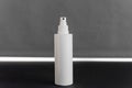 White spray bottle on a grey background