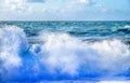White spray of a wave breaking on the beach with a rough sea and sky behind Royalty Free Stock Photo