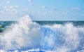 White spray of a wave breaking on the beach with a rough sea and sky behind Royalty Free Stock Photo