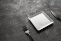 a white square empty plate, a black fork and knife. Stylish dinnerware for desserts. table setting. Suitable for Royalty Free Stock Photo