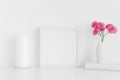 White square frame mockup with pink roses in a vase and workspace accessories on a white table Royalty Free Stock Photo