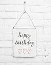 White square metal plate on white bricks background - with text happy birthday