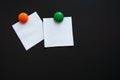 White square note stickers are attached with colored magnets on a black Board. Royalty Free Stock Photo