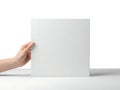 White square object held by hand against white background stock image Royalty Free Stock Photo