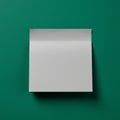A white square sticky note pad is placed against a plain green background. The pad Royalty Free Stock Photo