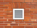 White ventilation grate set in a red brick wall with arched brickwork orange texture Royalty Free Stock Photo