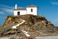White stairs leading up from the beach to a small white chapel with a bell tower on a hill Royalty Free Stock Photo