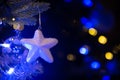 White star hanging on a Christmas tree, Christmas ornaments at night blue and gold holiday lights Royalty Free Stock Photo