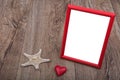 White starfish, heart and photo frame on a wooden background