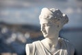 White statue of Artemis, Diana goddess with blurred greek cityscape Royalty Free Stock Photo