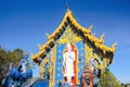 White Statue of the great standing Buddha behind the Ubosot of Wat Rong Suea Ten, or Blue Temple in Chiang Rai, Thailand