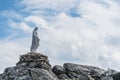 White statue of Virgin Mary, Mother of God, placed on top of the mountains. In the background there are snowy peaks Royalty Free Stock Photo