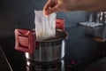 White steamed rice in portion bags for cooking. Cooking rice, a woman puts a bag for cooking in a pot