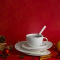 White steaming cup of hot tea or coffee with teaspoon with white mockup handle on the pile of saucers on red background Royalty Free Stock Photo