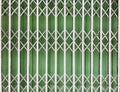 White steel folding door with a green metal sheet background Royalty Free Stock Photo