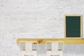 Steel Stools with Wooden Shelf and Blank Black Chalkboard on White Brick Wall Background Royalty Free Stock Photo