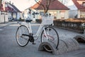 White step-through frame bicycle parked with antitheft system on city streets