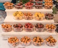White step type display of clear plastic containers holding various colors of cherry tomatoes. Royalty Free Stock Photo