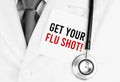 White sticker with text Get your flu shot lying on medical robe with a stethoscope Royalty Free Stock Photo