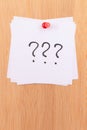 White Sticky Notes with Three Question Marks Pinned to the Wooden Message Board Royalty Free Stock Photo