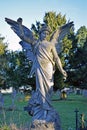 A white stone angel shaped mounument in a graveyard