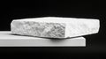 A white stone block sits atop a white rectangular platform against a black background. Royalty Free Stock Photo