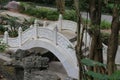 A white stone bridge with classical Chinese patterns, in the center of an outdoor garden area Royalty Free Stock Photo