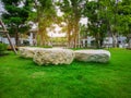 The white stone decorated on fresh green Burmuda grass smooth lawn as a carpet, bush and trees on the background, good maintenance Royalty Free Stock Photo