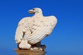 White stone eagle guards the gate to Bahai Gardens over blue sky in Haifa