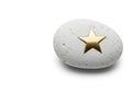 A white stone with a golden star. Space for text. Royalty Free Stock Photo