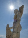 Grecian Statue against blue sky with sun