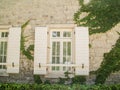 White stone house wall with white window with green ivy Royalty Free Stock Photo