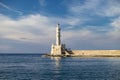 White stone lighthouse in the small marine bay of the old town on the mediterranean island