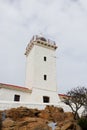 White Stone Lighthouse Tower On Rock With Overcast Sky Royalty Free Stock Photo