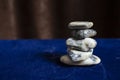 White stones stack on blue velvet and brown courtains, serene zen backdrop for wellness