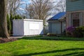 White storage pod unit in the driveway of a home that has solar panels. Royalty Free Stock Photo