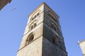 White stork flying over Santa Maria la Mayor church, Trujillo, Spain