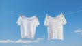 White and striped t-shirts drying on a clothes line, on blue sky background. Clean laundry. Generative AI