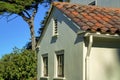 White stucco facade or exterior of house home with front or back yard shrubs and trees with blue sky background in sun Royalty Free Stock Photo