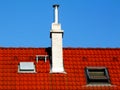 white stucco finished chimney stack. metal baffle deflector cap. red clay roof tiles Royalty Free Stock Photo