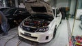 White Subaru WRX STI hatchback on car workshop showing the engine Royalty Free Stock Photo